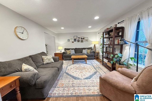 living area with recessed lighting, a textured ceiling, and wood finished floors