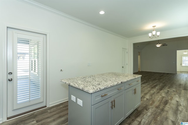 kitchen featuring an inviting chandelier, dark wood-type flooring, a kitchen island, and ornamental molding