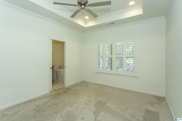 carpeted spare room with baseboards, a raised ceiling, ornamental molding, and a ceiling fan