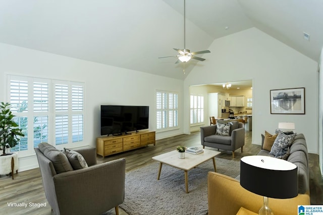 living area featuring visible vents, high vaulted ceiling, wood finished floors, and a ceiling fan