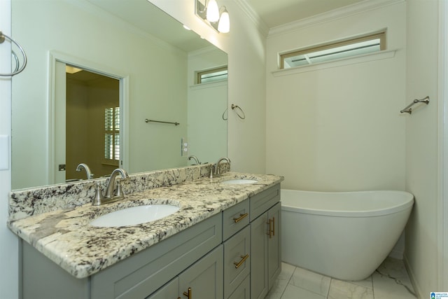 full bath with a sink, a freestanding bath, marble finish floor, and ornamental molding