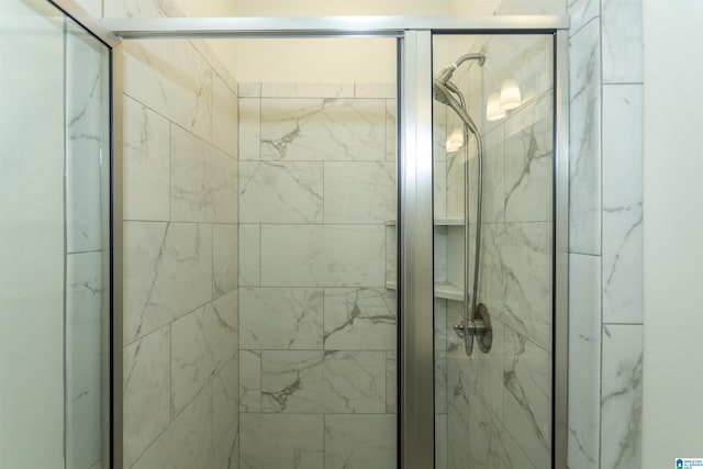 bathroom featuring a marble finish shower