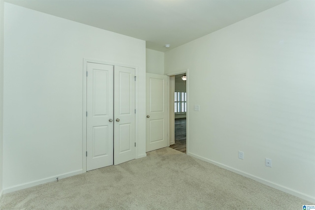 unfurnished bedroom with carpet flooring, baseboards, and a closet