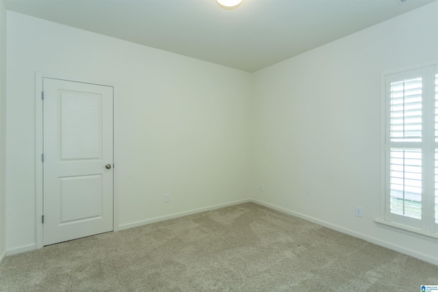 carpeted spare room with baseboards and a wealth of natural light