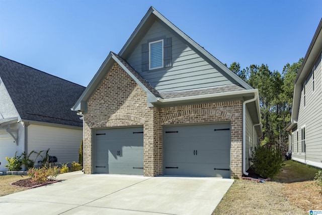 view of front of house with brick siding, driveway, and a garage