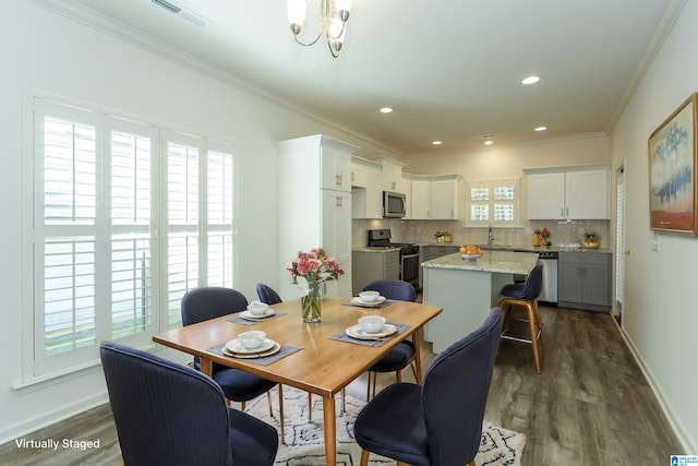 dining area with a notable chandelier, visible vents, crown molding, and dark wood-style flooring