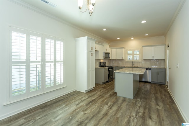 kitchen featuring dark wood-style floors, visible vents, a sink, appliances with stainless steel finishes, and tasteful backsplash