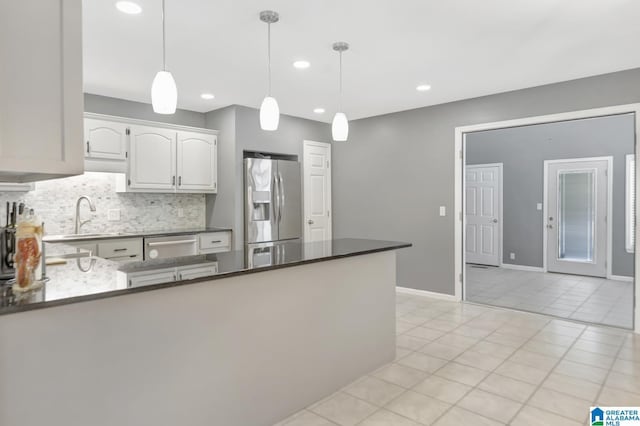 kitchen with a sink, decorative light fixtures, tasteful backsplash, appliances with stainless steel finishes, and a peninsula