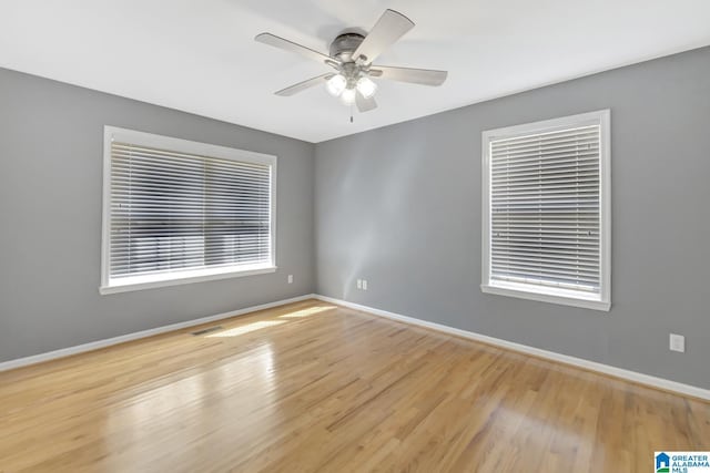 empty room with wood finished floors, baseboards, and ceiling fan