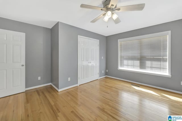 unfurnished bedroom with light wood-style floors, baseboards, and a closet