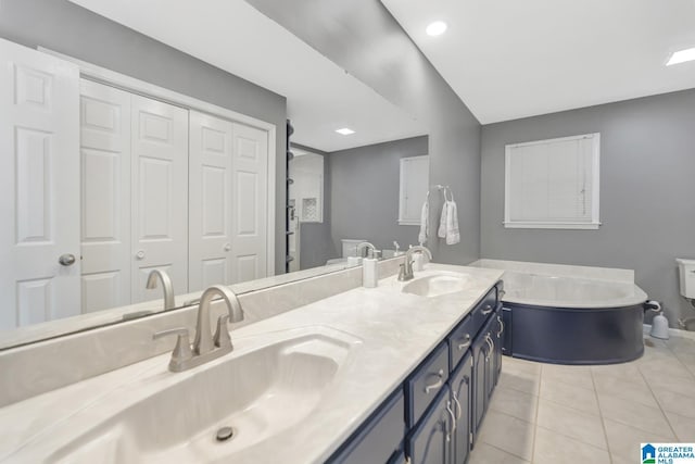 bathroom featuring a sink, a bath, double vanity, and tile patterned flooring