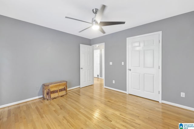 unfurnished bedroom featuring light wood finished floors, a ceiling fan, and baseboards