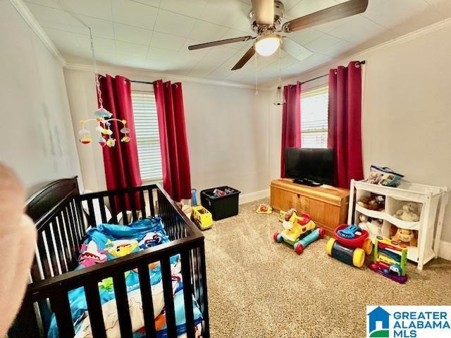 bedroom with baseboards, a ceiling fan, carpet flooring, and crown molding