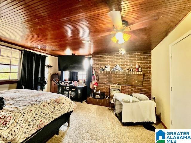 carpeted bedroom with wooden ceiling and brick wall