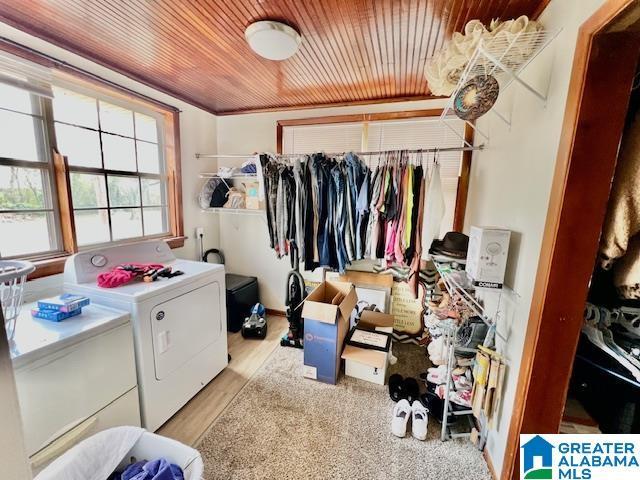 washroom featuring wooden ceiling, washing machine and dryer, laundry area, and light wood-style flooring