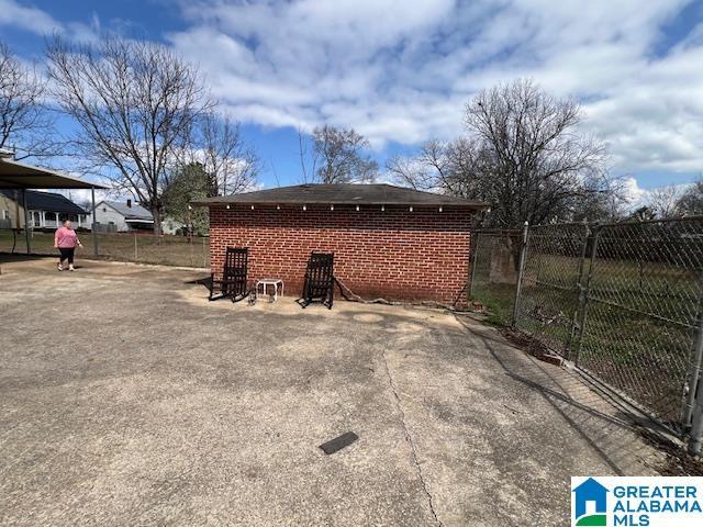 back of property featuring brick siding and fence