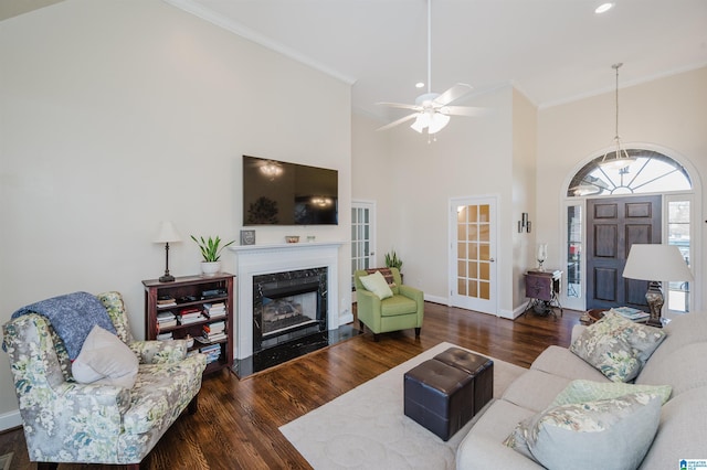 living room with wood finished floors, a high end fireplace, and ornamental molding