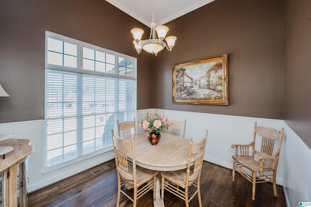 dining room with a wainscoted wall, wood finished floors, plenty of natural light, and a chandelier