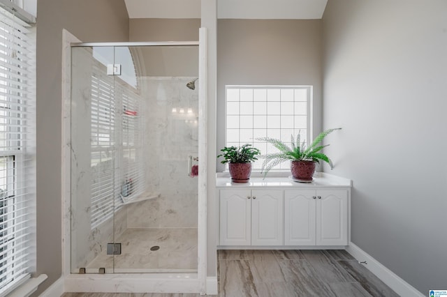 full bathroom with a stall shower and baseboards