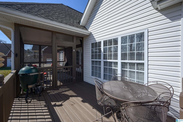 deck with outdoor dining area, a sunroom, and a grill