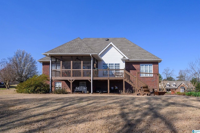 back of property with a wooden deck, brick siding, stairs, and a sunroom