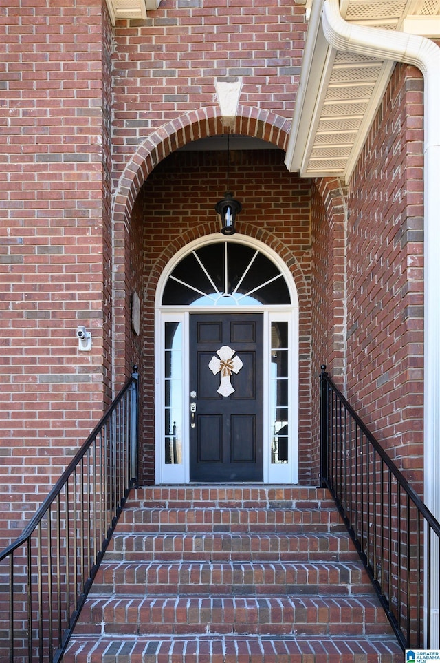 entrance to property featuring brick siding