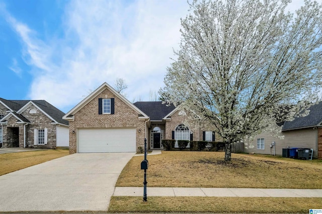 traditional-style home with brick siding, an attached garage, concrete driveway, and a front yard