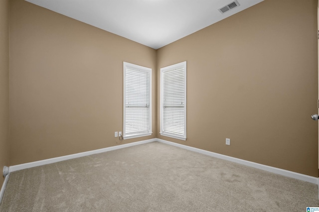 carpeted empty room with visible vents and baseboards