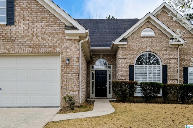 view of front of house featuring brick siding, an attached garage, a shingled roof, and concrete driveway