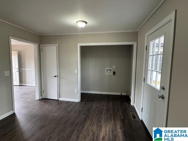 interior space featuring visible vents, crown molding, dark wood-type flooring, and baseboards