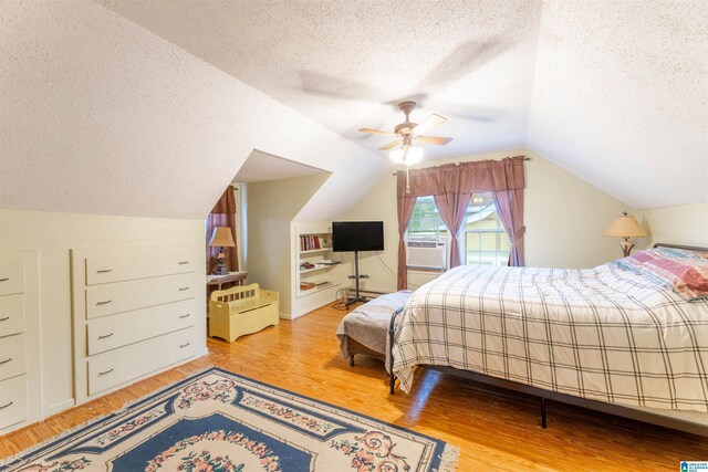819 Jefferson Ave, Anniston, AL 36207 - bedroom with light wood finished floors, ceiling fan, vaulted ceiling, cooling unit, and a textured ceiling