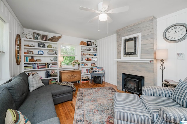 5242 Roy Dr, Helena, AL 35080 - living room featuring wood finished floors, ceiling fan, a wood stove, and crown molding