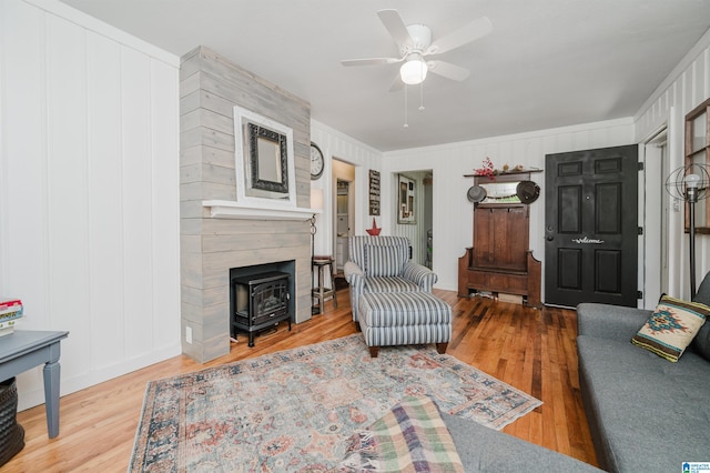 5242 Roy Dr, Helena, AL 35080 - living room with ceiling fan, wood finished floors, ornamental molding, a decorative wall, and a wood stove