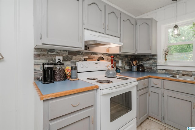 5242 Roy Dr, Helena, AL 35080 - kitchen featuring white electric stove, under cabinet range hood, gray cabinetry, backsplash, and ornamental molding