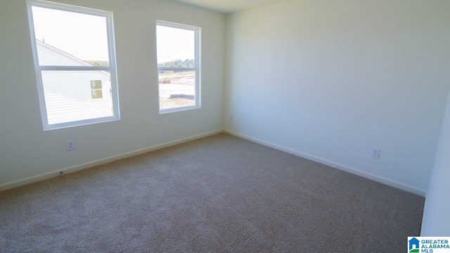 carpeted spare room featuring baseboards