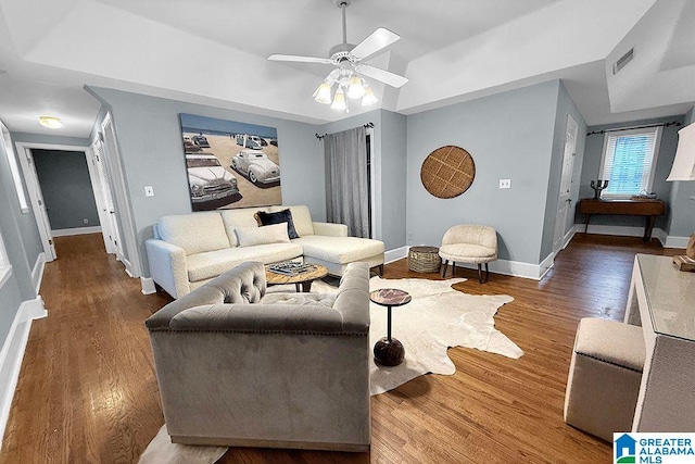 living room with visible vents, baseboards, a ceiling fan, and wood finished floors