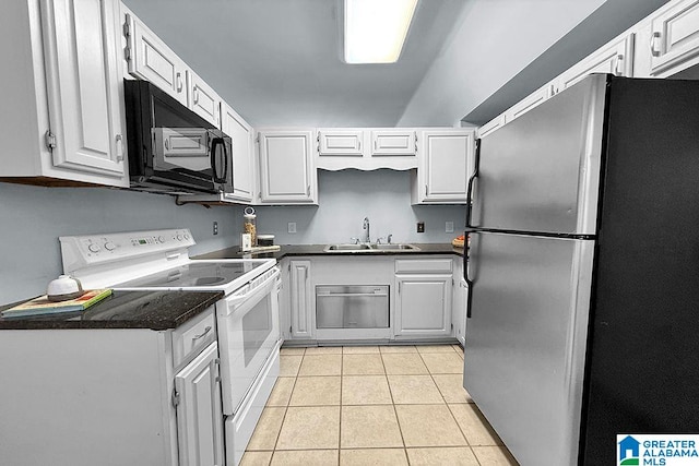 kitchen with a sink, dark countertops, white electric range oven, freestanding refrigerator, and black microwave