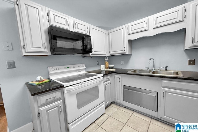 kitchen with a sink, dark countertops, black microwave, and white range with electric cooktop