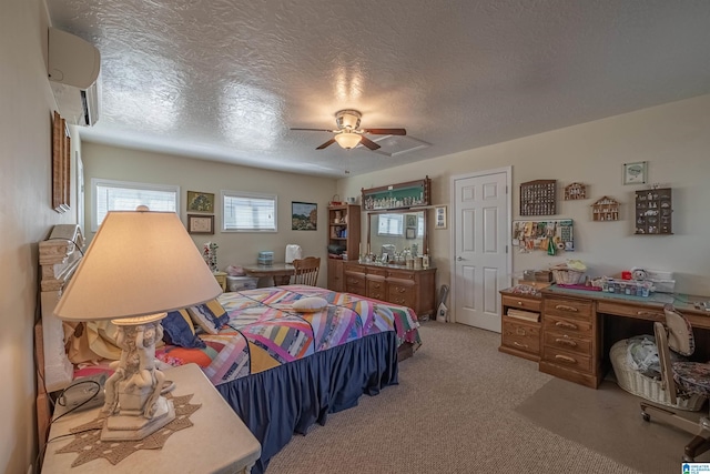 bedroom with a wall mounted air conditioner, light colored carpet, a ceiling fan, and a textured ceiling