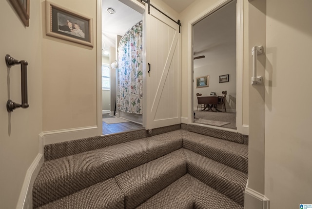 stairway with baseboards and a barn door