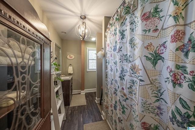 full bath featuring curtained shower, baseboards, an inviting chandelier, wood finished floors, and vanity