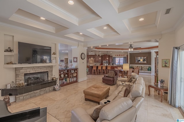 living room featuring visible vents, a stone fireplace, a ceiling fan, and crown molding