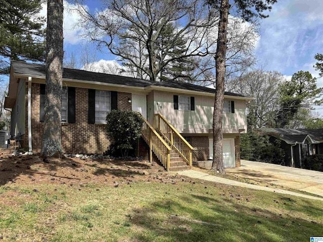 view of front of house with stairway, driveway, an attached garage, central air condition unit, and brick siding