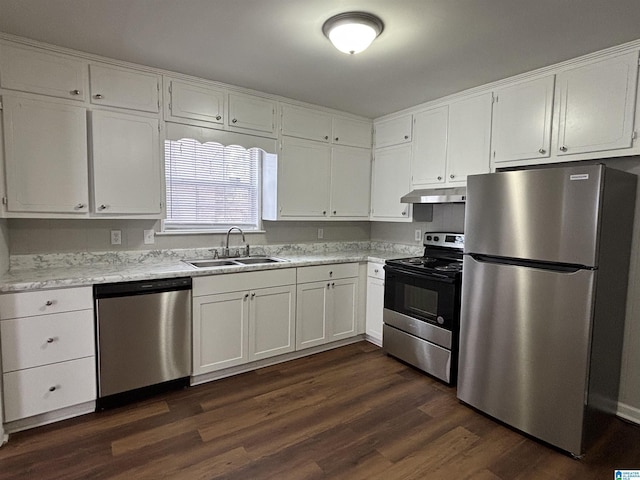 kitchen with under cabinet range hood, white cabinetry, appliances with stainless steel finishes, and a sink