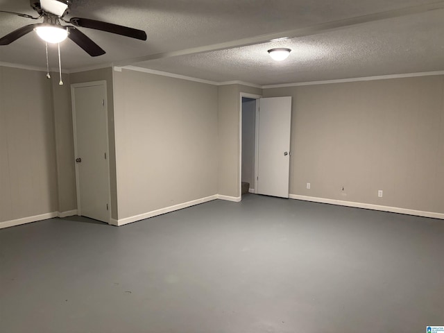 spare room featuring a ceiling fan, finished concrete flooring, baseboards, ornamental molding, and a textured ceiling