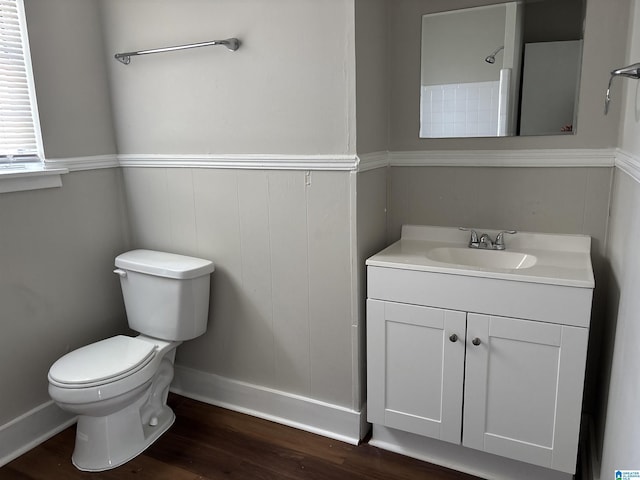 bathroom with toilet, wood finished floors, and vanity