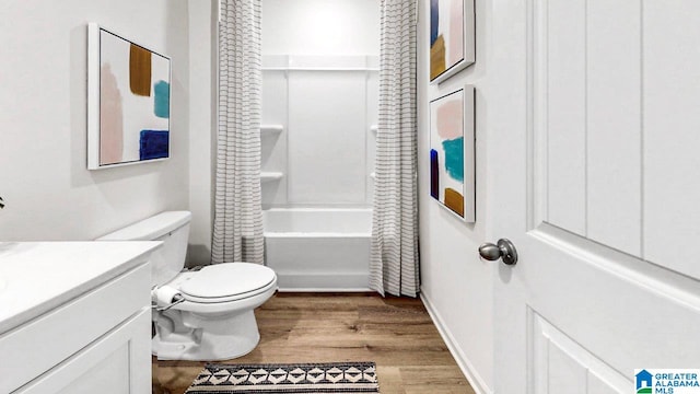 full bathroom featuring vanity, toilet, wood finished floors, and shower / tub combo with curtain