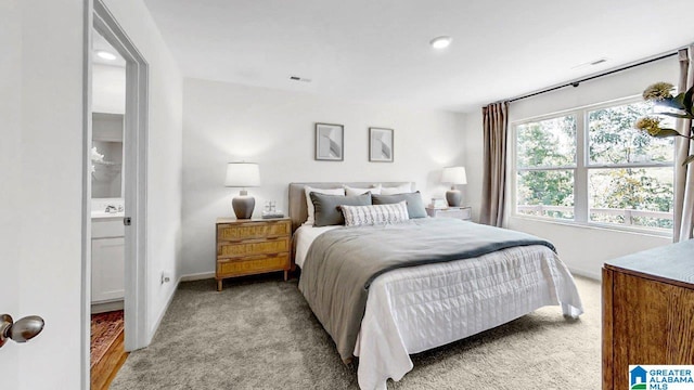 bedroom featuring baseboards, visible vents, and light carpet