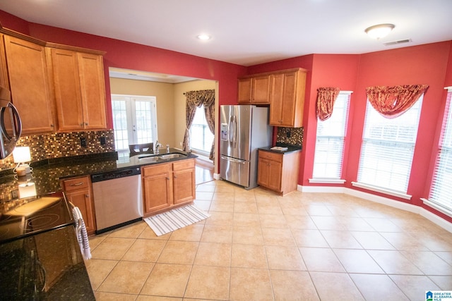 kitchen featuring visible vents, a sink, stainless steel appliances, a peninsula, and light tile patterned flooring