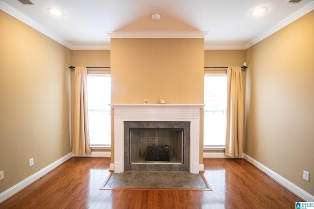 unfurnished living room featuring baseboards, a healthy amount of sunlight, wood finished floors, and a fireplace with flush hearth